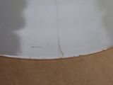 a white plate on a wooden table with a knife in it