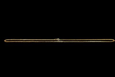 gros plan d'un bracelet en or sur fond noir