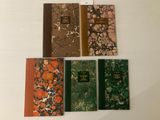 quatre livres sont alignés sur une surface blanche