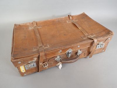 a brown suitcase sitting on a table with a tag on it