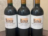 trois bouteilles de vin posées sur une table en bois