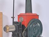 a small red and black machine next to a brown box