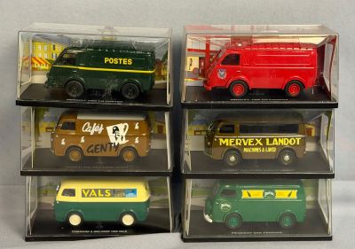 Quatre types différents de camions miniatures sont exposés dans une vitrine.