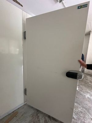 une porte blanche avec une poignée noire dans une pièce