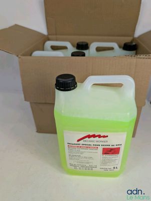 une bouteille de liquide posée dans une boîte en carton