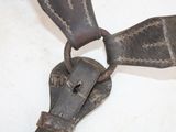 an old metal object on a table with a leather strap