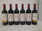 four bottles of wine are lined up on a table