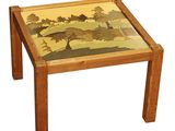 a small wooden table with a painting on the top of it