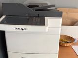 a printer sitting on top of a desk next to a pile of papers