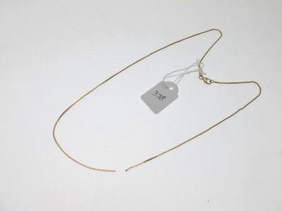 un collier muni d'une étiquette, posé sur une surface blanche
