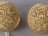 une paire de boucles d'oreilles dorées au motif maillé