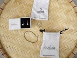 two pairs of earrings sitting on a table next to a bag
