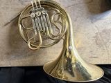a close up of a brass french horn on a black cloth