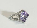 a close up of a ring with an amethorate and diamonds