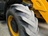 a large yellow wheel on the back of a construction vehicle