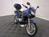 a blue motorcycle parked in a room with a checkered floor