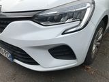the front end of a white car parked on the side of the road