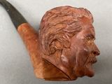 a carved pipe with a man ' s face on it