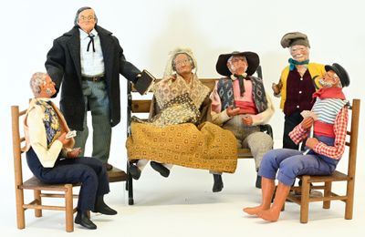 many figurines of people sitting on a bench together