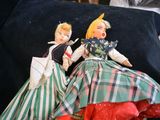 two dolls that are sitting on a black pillow