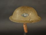 an old helmet with a diamond on it is on a stand