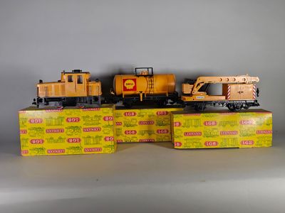 deux petits trains posés sur des cartons, sur une table