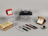 beaucoup de stylos, une horloge, une boîte et une montre