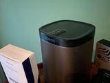 a black and silver speaker sitting on a table next to a box