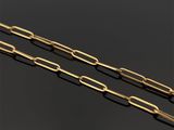 une paire de trombones plaqués or sur un fond noir