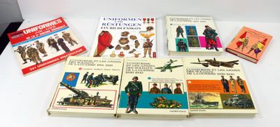 plusieurs livres posés sur une table recouverte d'une nappe blanche et d'une nappe blanche