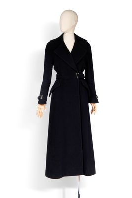 Le manteau est noir et est muni d'une ceinture.