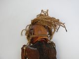 une petite poupée en bois avec une corde autour du cou