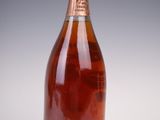 an old bottle of wine sitting on top of a white table