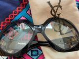 sunglasses and a pouch on a table with a blue and pink tie
