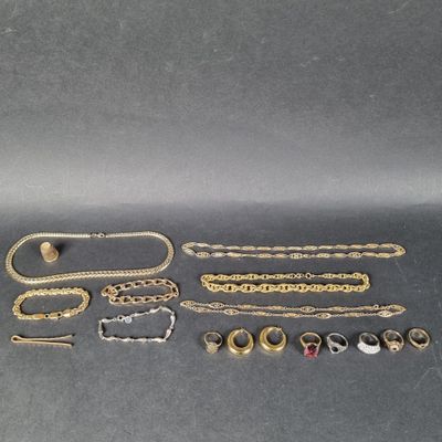 un ensemble de bijoux en or et en argent posés sur une surface grise