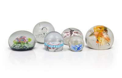 six glass eggs with different designs on them on a white surface