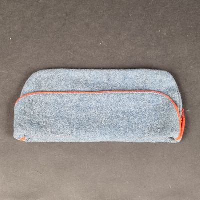 un gros plan sur une trousse de couleur grise et orange posée sur une table