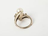a close up of a ring with a pearl on it