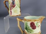pair of hand painted ceramic jugs with birds and flowers on them