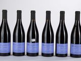 six bouteilles de vin sont alignées sur une table