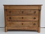 a small wooden chest of drawers on a white floor
