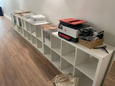 une étagère blanche sur laquelle sont posées de nombreuses boîtes, dans une pièce