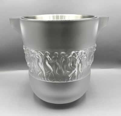 un vase en argent posé sur un socle en argent, sur une table blanche