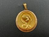 a close up of a gold plated pendant with an image of the virgin mary
