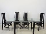 a glass dining table with four chairs around it