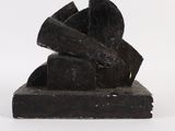 des sculptures en bois noir empilées les unes sur les autres sur une surface blanche