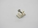 a white diamond ring sitting on top of a white surface
