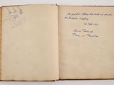 an open book with a handwritten note on it sitting on a table