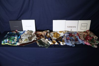 deux boîtes de foulards en soie posées sur une table recouverte d'une nappe bleue