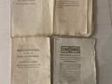 trois vieux livres exposés sur une table, accompagnés d'une étiquette en papier